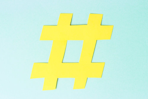 Hashtag sign isolated on blue background, close up, network concept